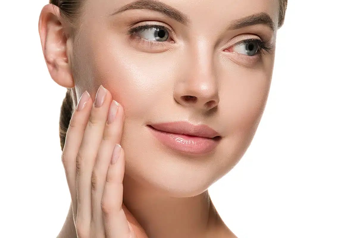 Beautiful woman face hands touching cheeks with healthy clean beauty skin