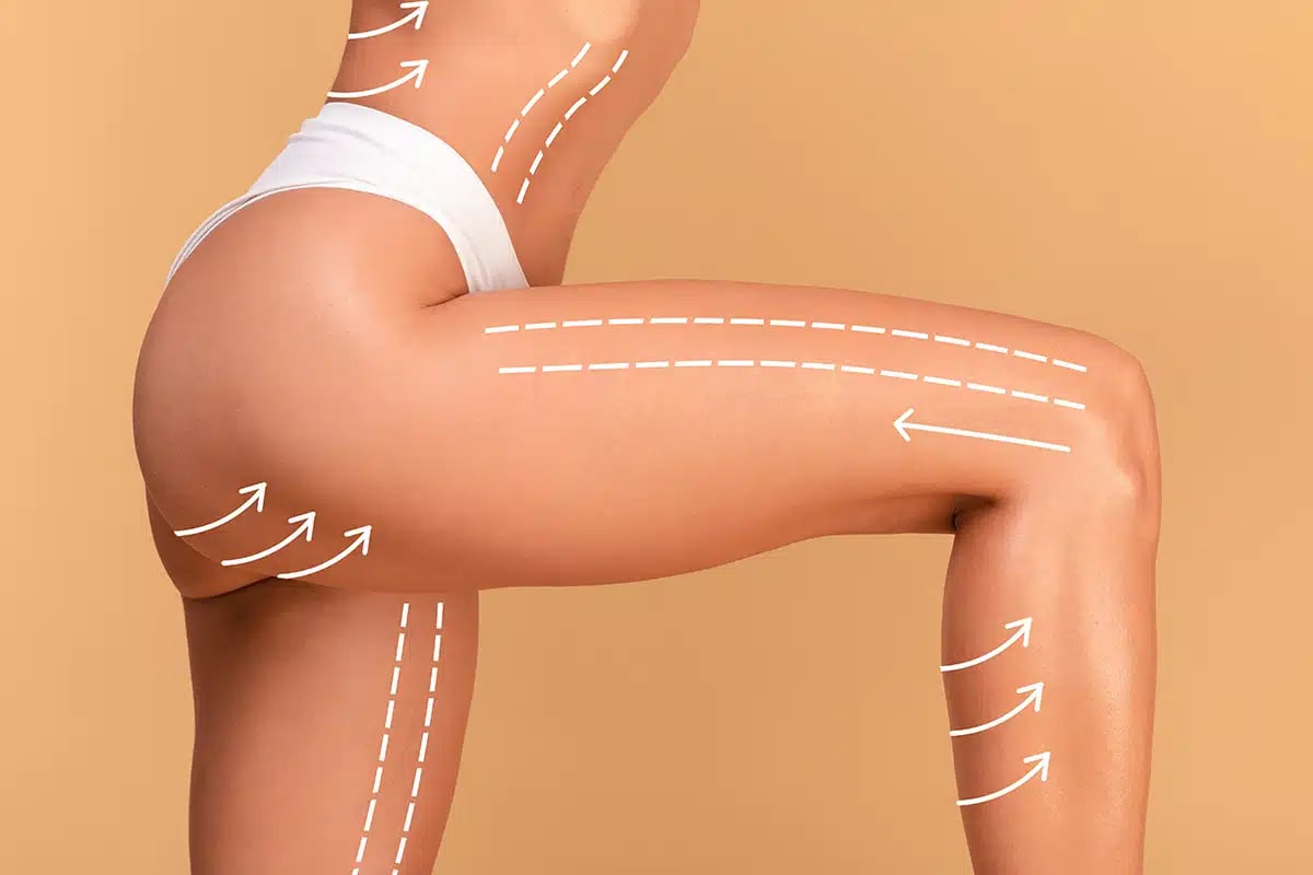 Closeup cropped shot of young woman in white panties posing with massage lines and arrows on her body