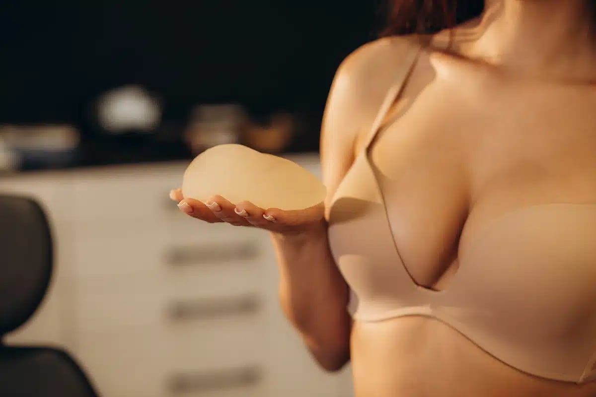 Woman holding silicone breast implant for breast augmentation